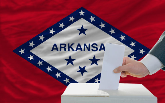 man voting on elections in front of flag US state flag of arkans