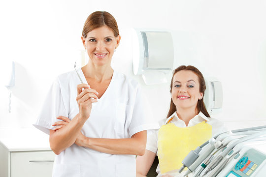Zahnarzthelferin neben Patientin