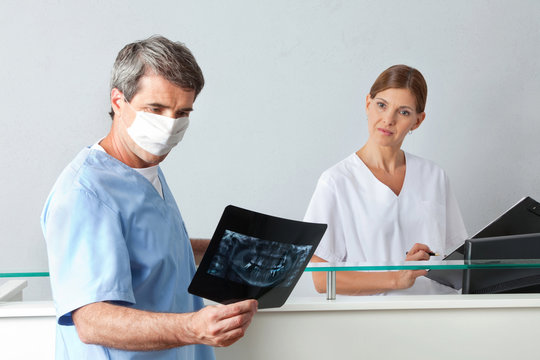 Zahnarzt schaut auf Röntgenbild