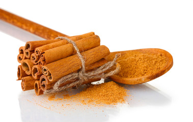 Cinnamon sticks and powder in wooden spoon isolated on white