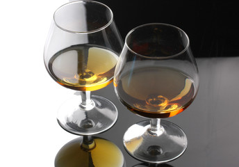 Two glasses of cognac on grey background