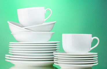 Clean plates, cups on green background