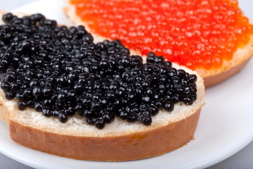 two sandwichs with red and black caviar on plate