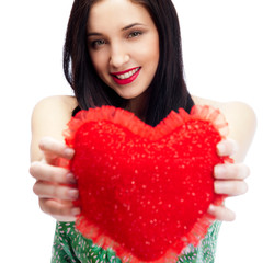 Cute young woman holds a heart symbol isolated on white backgrou