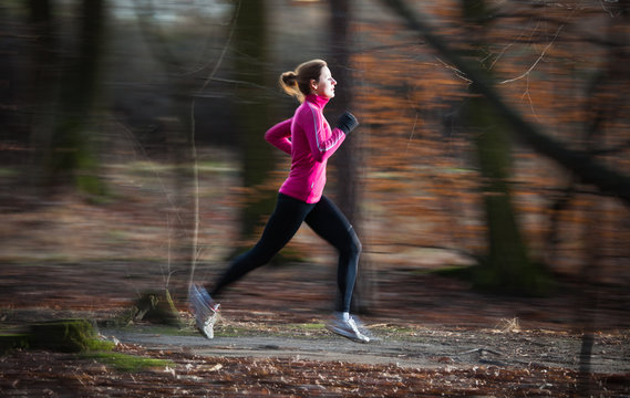 Young Woman Running Outdoors In A City Park On A Cold Fall