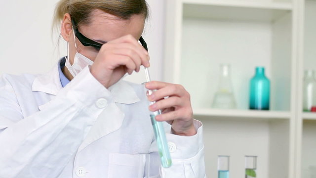 scientist mixing chemicals in test tube with stirring rod