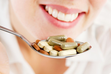 girl holding a spoon full of supplements