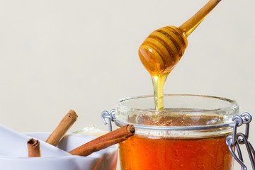 Honey dipper with jar on white background