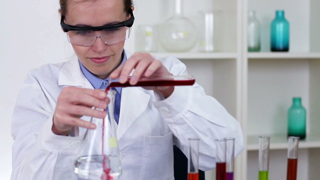 Female scientist mixing chemicals in erlenmeyer flask