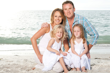 Fototapeta na wymiar Young family enjoy sunny day at the beach.