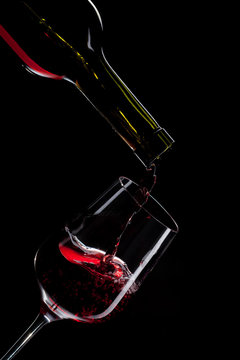 Red Wine Pouring Into Wine Glass Isolated On Black