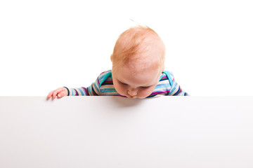 Isolated beaufiful caucasian infant baby behind whiteboard
