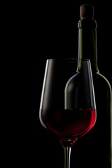 red wine in glass and bottle isolated on black