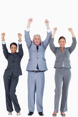 Three businesspeople with arms up