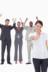 Fototapeta na wymiar Businesswoman with cheering colleagues behind her giving approva