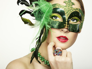 The beautiful young woman in a green mysterious venetian mask