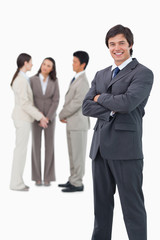 Smiling tradesman with folded arms and team behind him