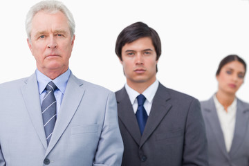 Mature salesman standing with employees