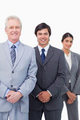 Smiling mature businessman with young employees