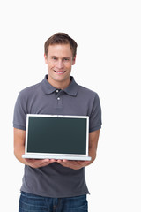 Smiling young man showing screen of his notebook