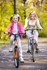 Fototapeta premium Mother and daughter on bicycle