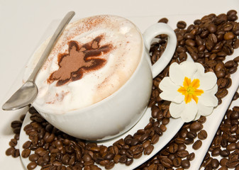 Cappuccino mit Kaffeebohnen und Blüte