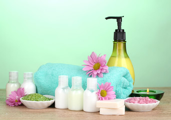 Hotel amenities kit on wooden table on blue background