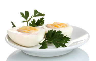 tasty boiled eggs and parsley on plate isolated on white