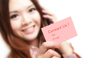 Smiling business woman holding a card (Contact Us) and speaking