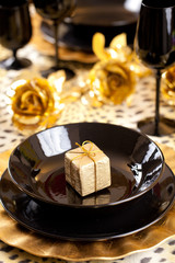 Black and gold place setting and gift box