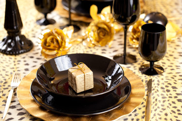 Black and gold place setting and gift box