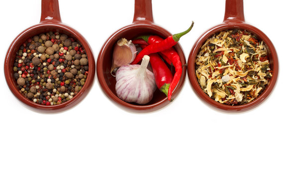 Spices and garlic in ceramic bowls.