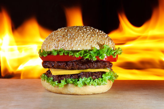 big hamburger with real fire on a background