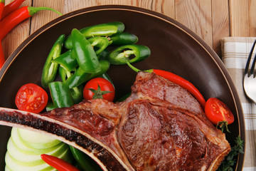 savory : grilled spare rib on dark dish with pepper and tomato