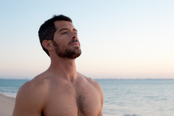 Handsome muscular man on the beach.