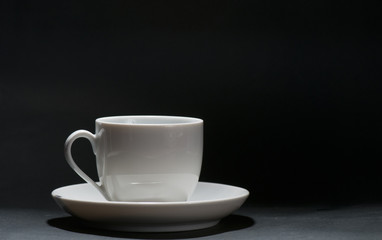 A white cup in front of black background