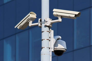 three cctv security cameras on street pylon