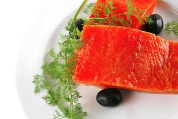 pink smoked salmon on white plate with olives