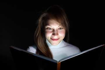 Young woman reading a magic book