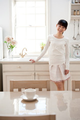attractive asian woman relaxing in kitchen