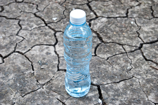 Cracked ground with water in a bottle
