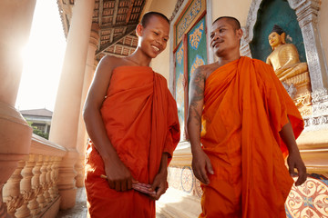 Two monks meet and salute in a buddhist monastery, Asia - obrazy, fototapety, plakaty