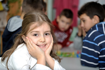 Obraz premium Happy little girl in school with her friends arround