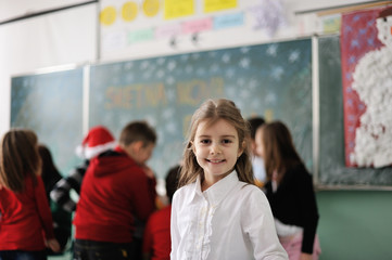 Happy little girl in school with her friends arround