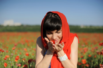 Young woman smelling poppies