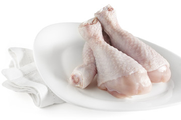 Fresh raw chicken legs on white plate