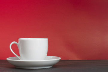 A white cup in front of red background
