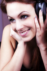 Girl smiling and listening to music on headphones.