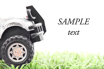 Toy Truck Driving on Grass with Space for Text