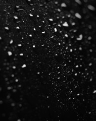 Extreme Close up of water drops on black surface